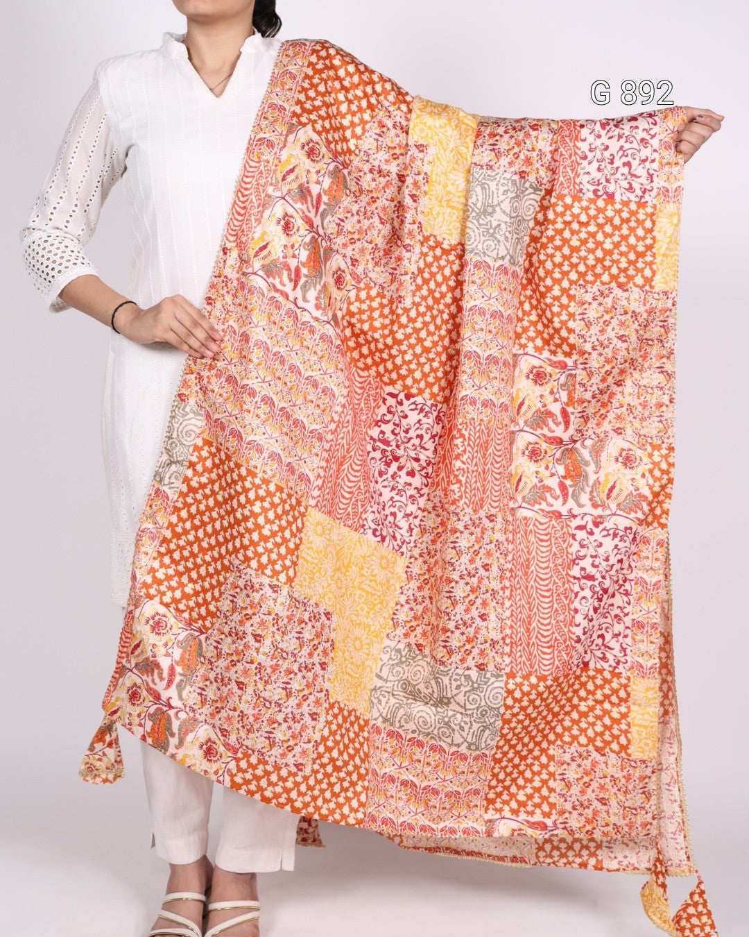 Person holding a colorful patterned scarf with a white background