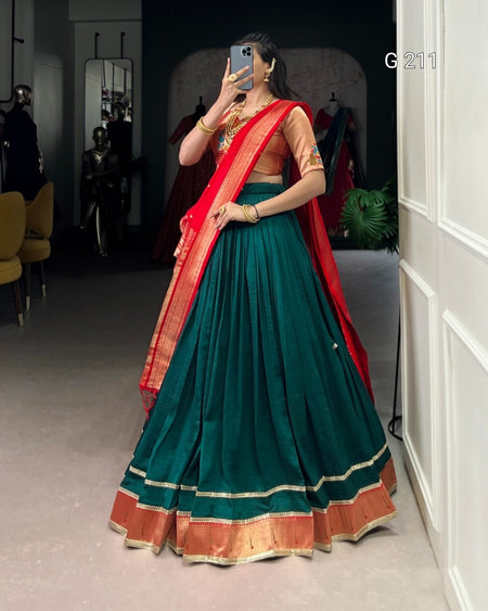 Person wearing a green and red traditional outfit in a room setting.