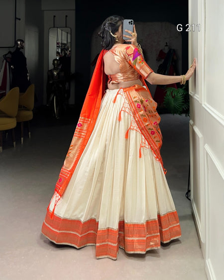 Person wearing a traditional outfit with orange and white design, taking a mirror selfie.