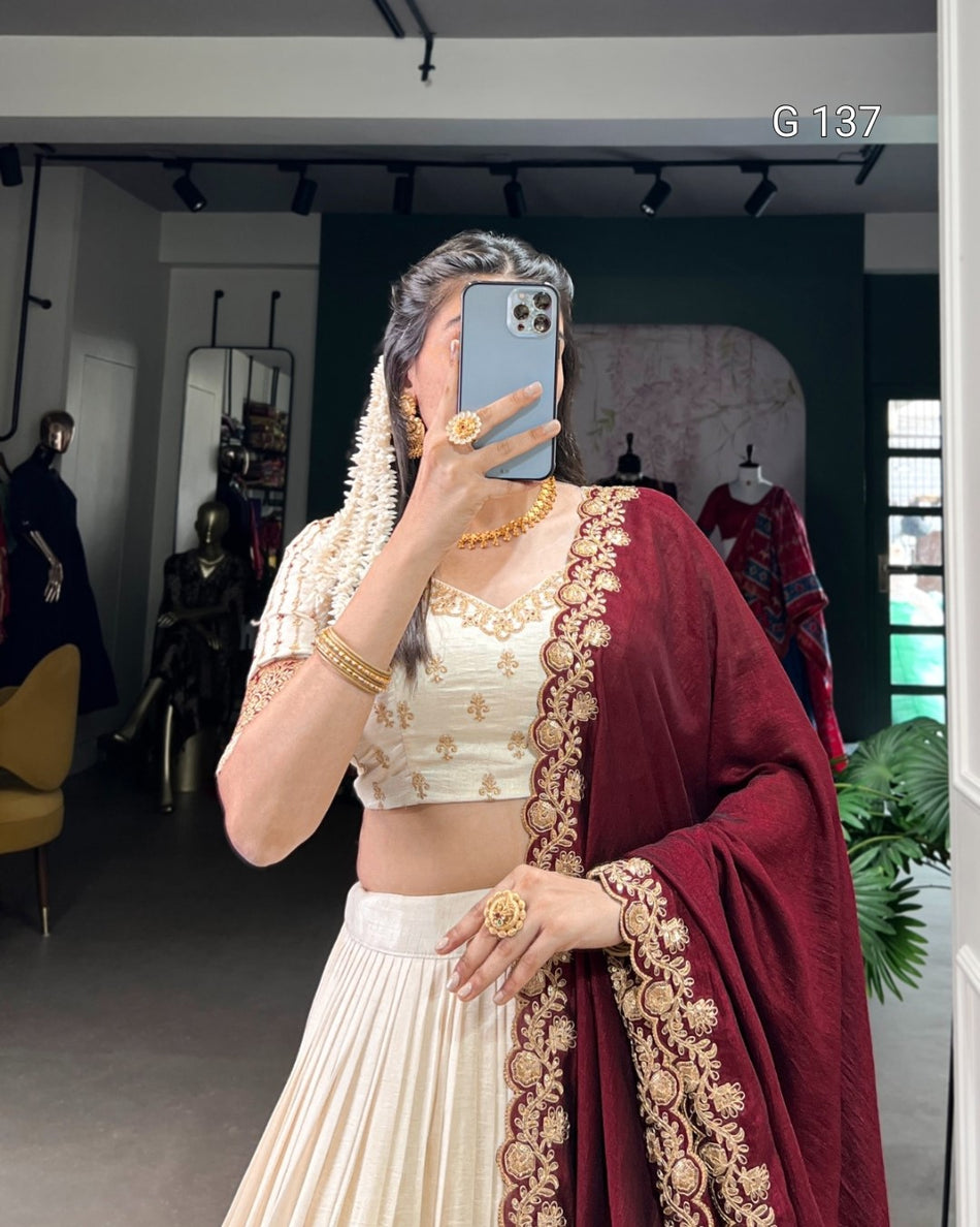 Person wearing traditional Indian attire with a maroon dupatta and gold jewelry in a store setting.