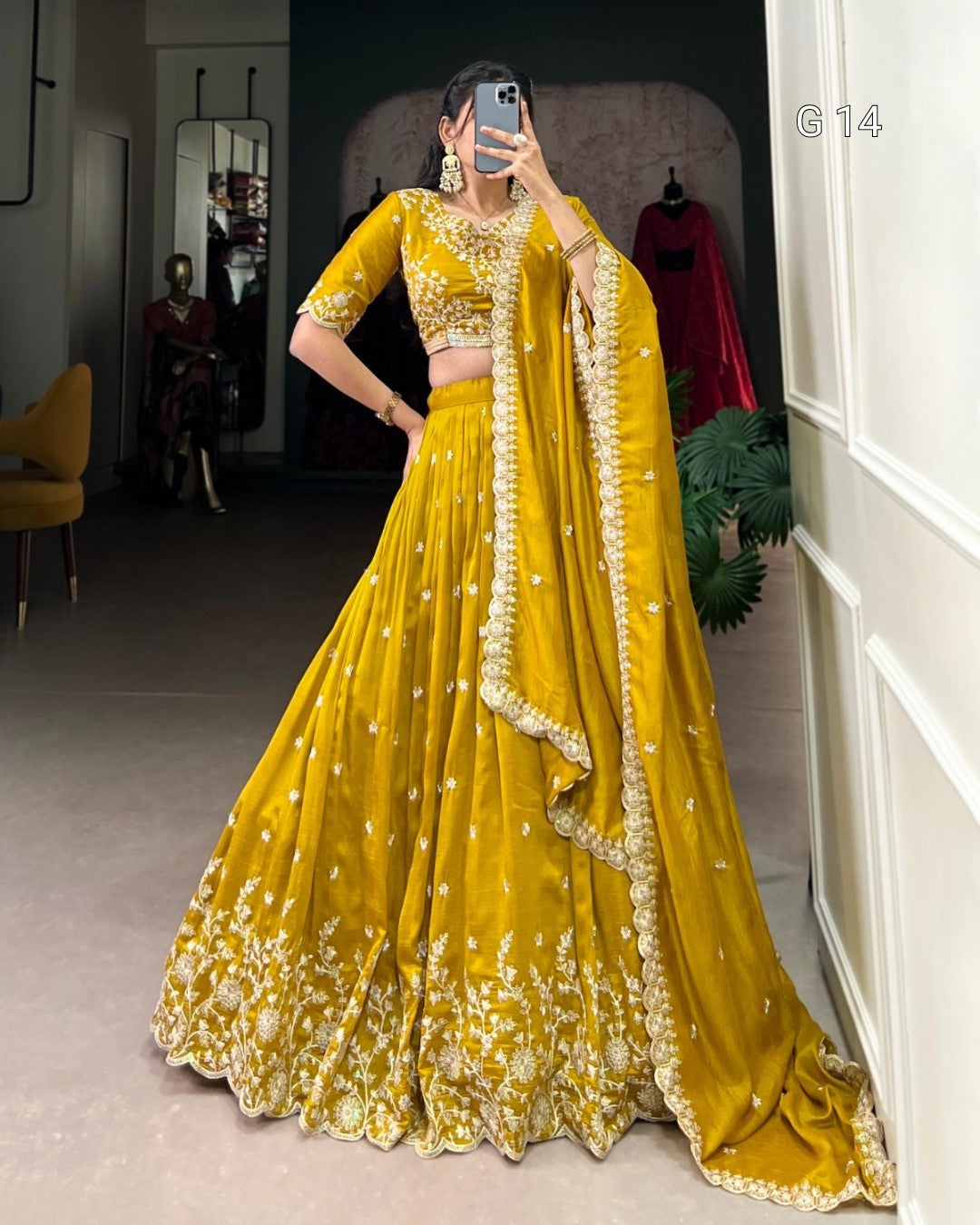 Person wearing a yellow embroidered traditional outfit in a room.