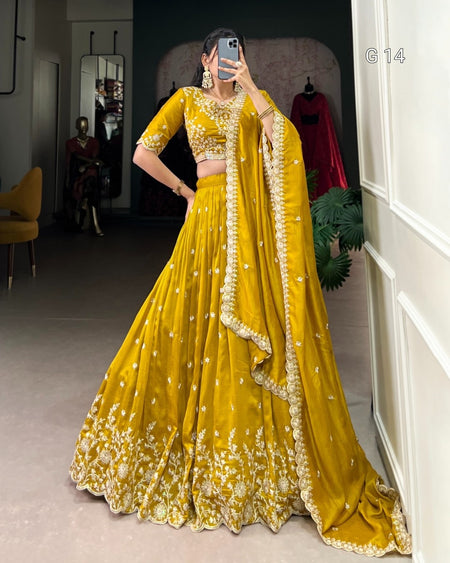 Person wearing a yellow embroidered traditional outfit in a room.