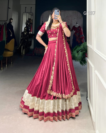Person wearing a traditional maroon and white outfit with gold details in a room.