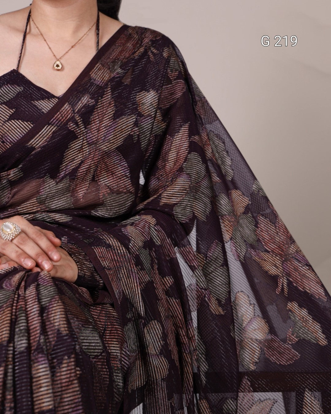 Woman wearing a patterned saree with a neutral background
