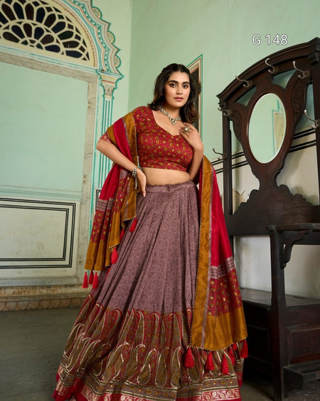 Woman wearing a traditional outfit with a red and brown patterned dupatta in an indoor setting.