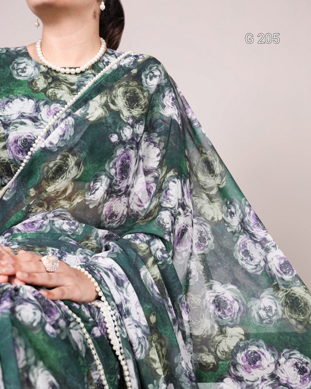 Floral patterned fabric with green, purple, and white colors on a plain background.