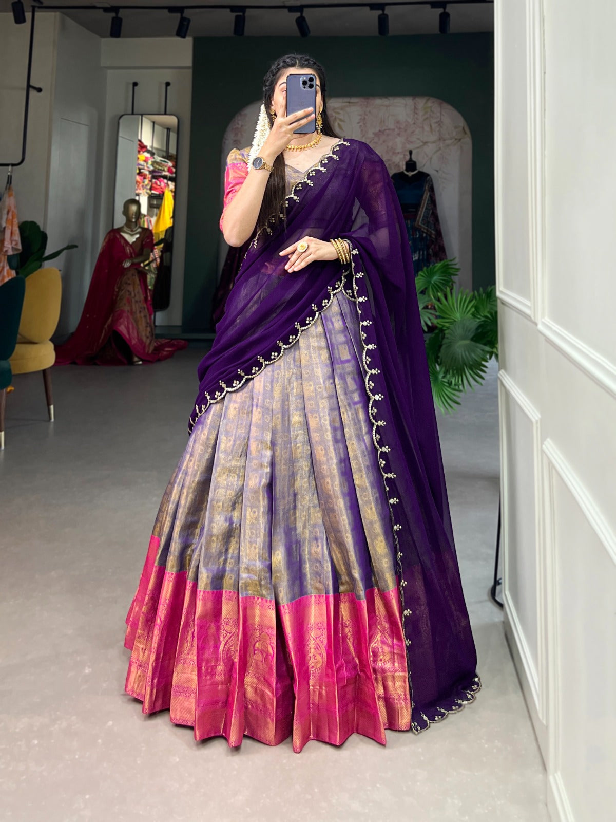 Woman wearing a purple and pink saree with a white background