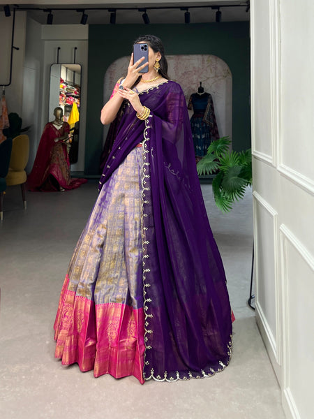 Woman wearing a colorful saree with a mirror reflection in a room.