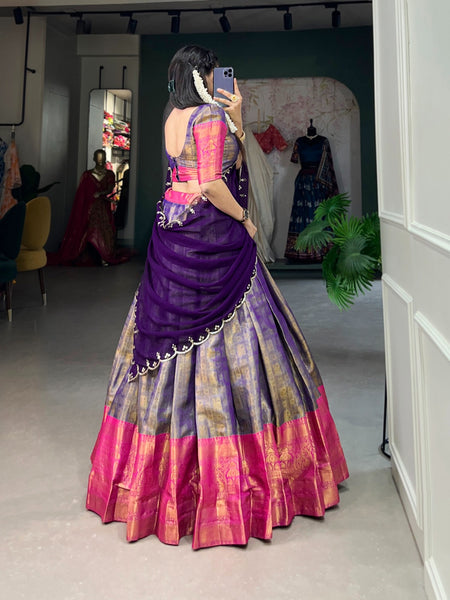 Person wearing a colorful saree with a mirror reflection in a room.