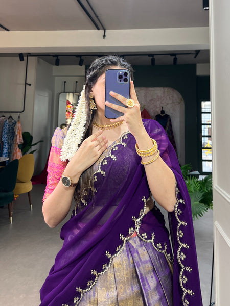 Person wearing a purple saree with gold embroidery in an indoor setting.