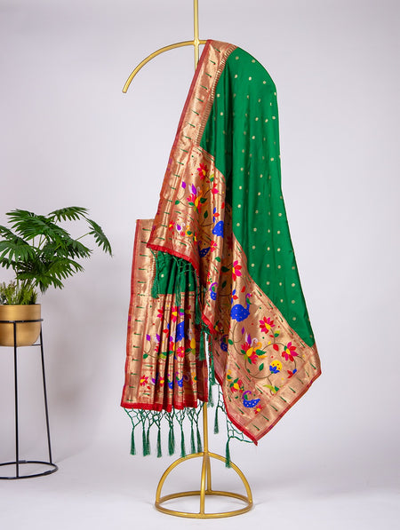 Green and gold saree with floral embroidery on a stand against a white background