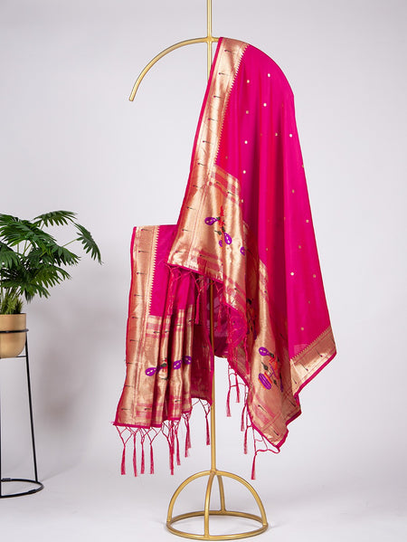 Pink saree with gold border on a gold stand against a white background