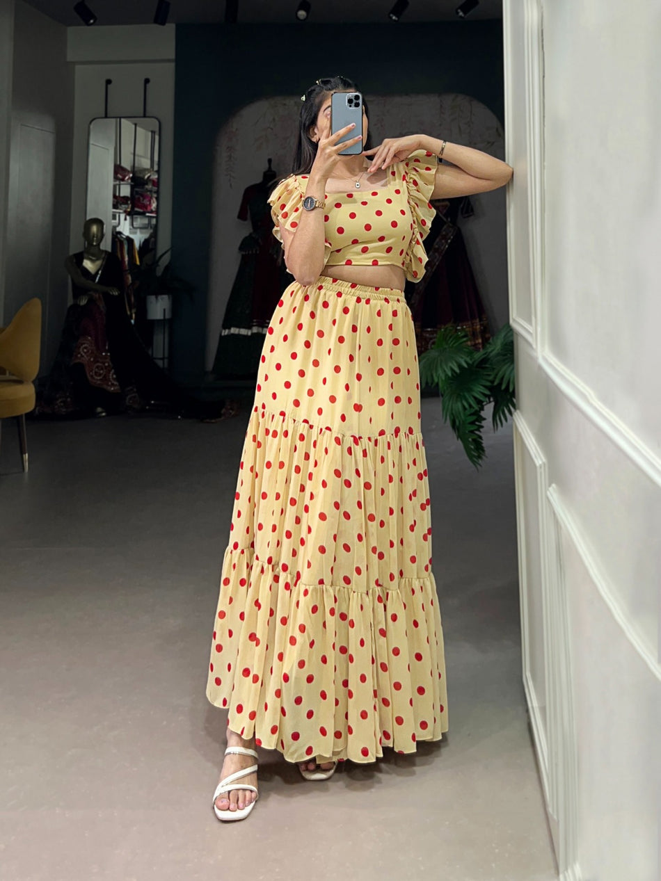 Woman taking a mirror selfie wearing a yellow polka dot dress in a room.