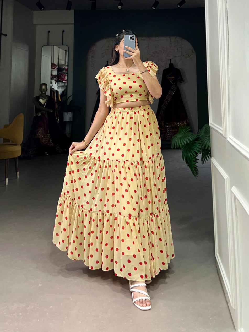 Woman wearing a yellow dress with red polka dots in an indoor setting.