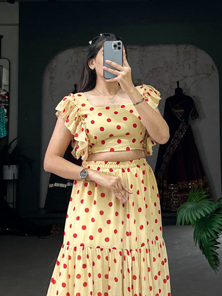 Woman wearing a yellow polka dot dress taking a mirror selfie.