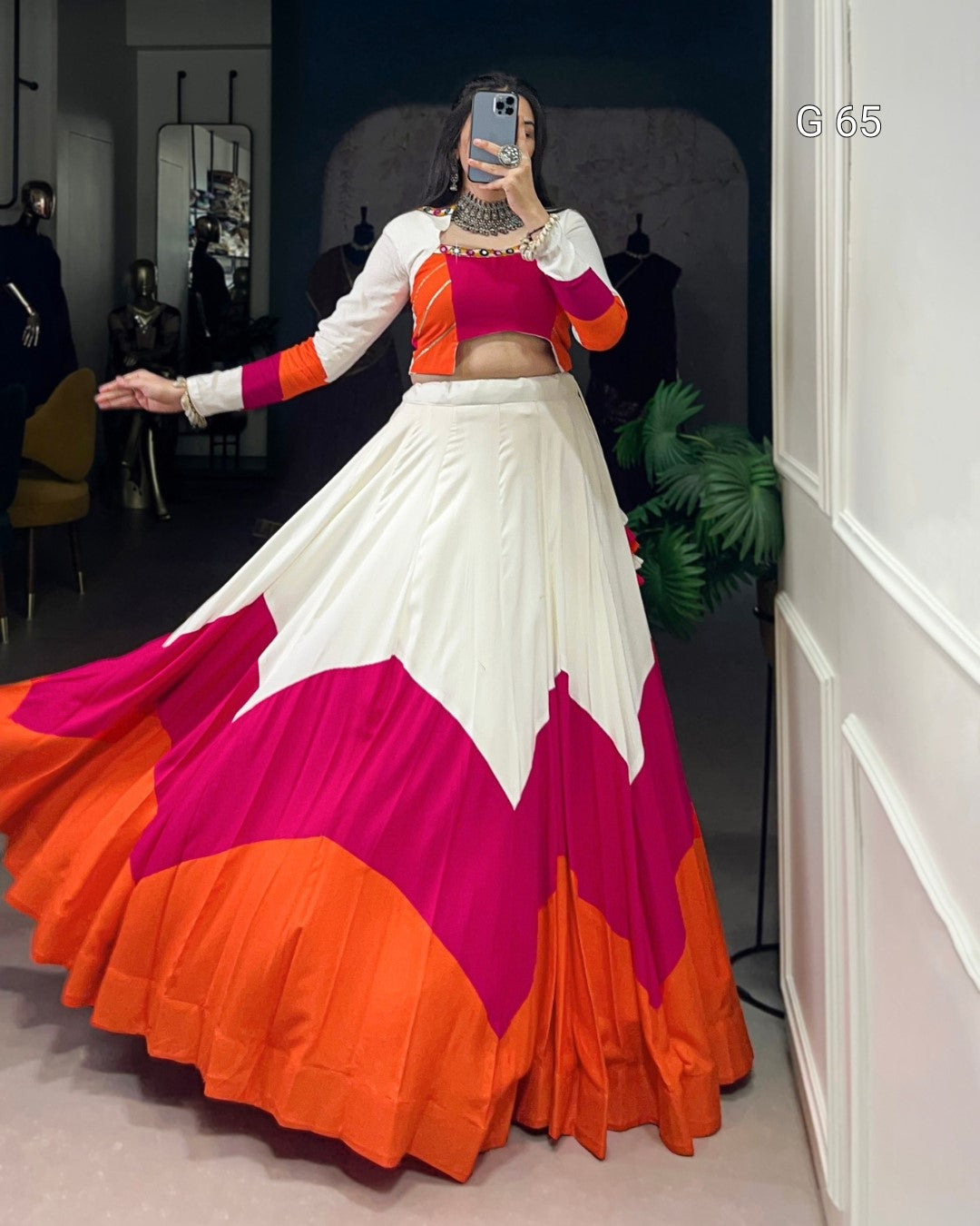 Colorful traditional outfit with a white, pink, and orange design in a room.