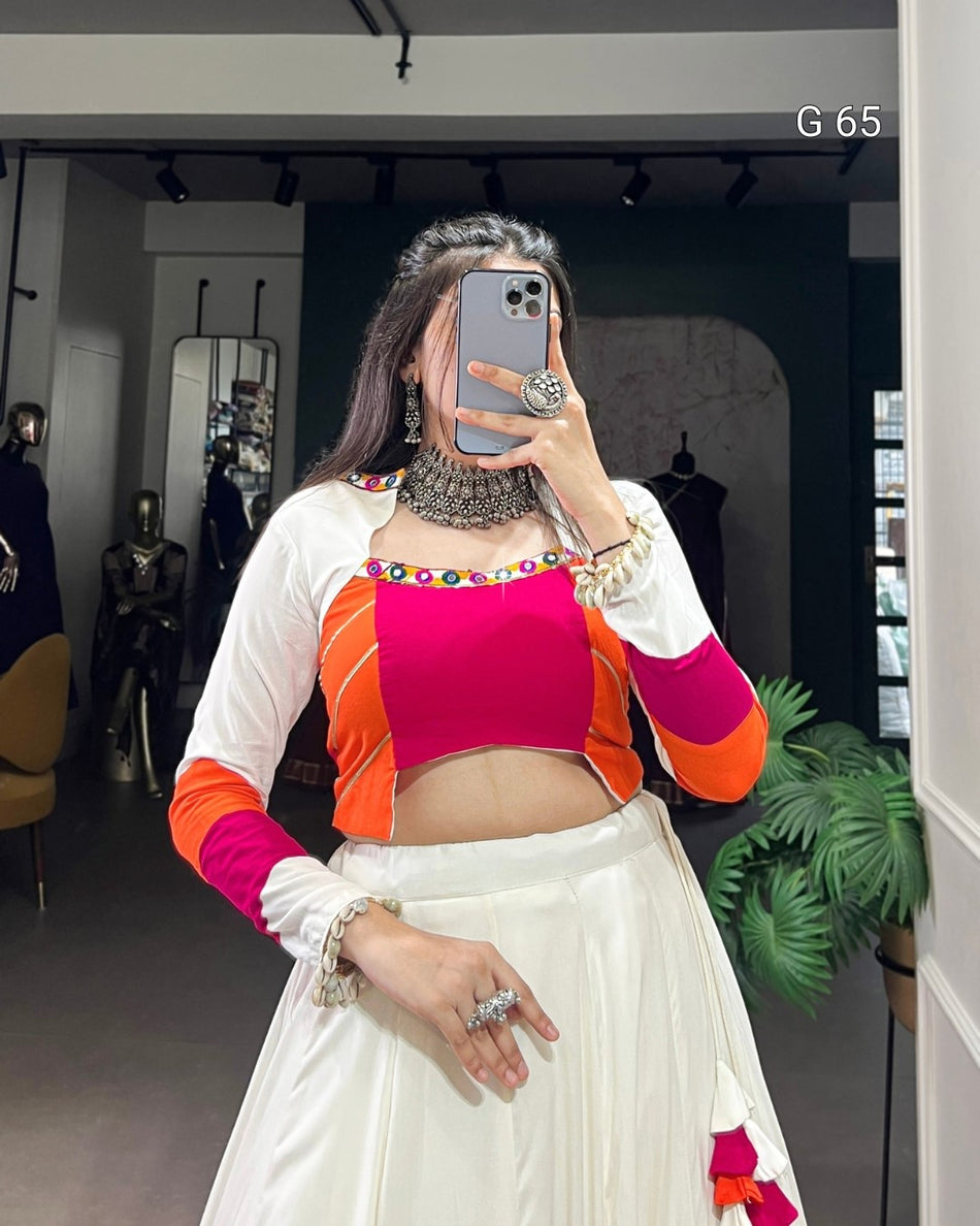 Person taking a mirror selfie wearing a colorful outfit with a white background.