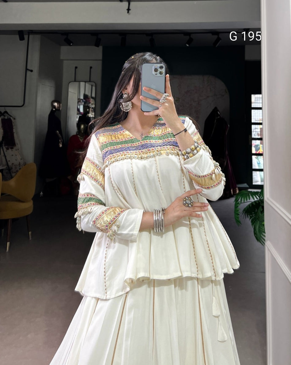Person wearing a colorful dress with intricate patterns in a room.