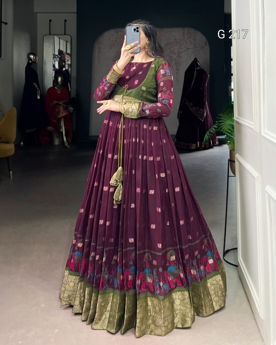 Woman wearing a traditional maroon and green outfit with floral patterns indoors.