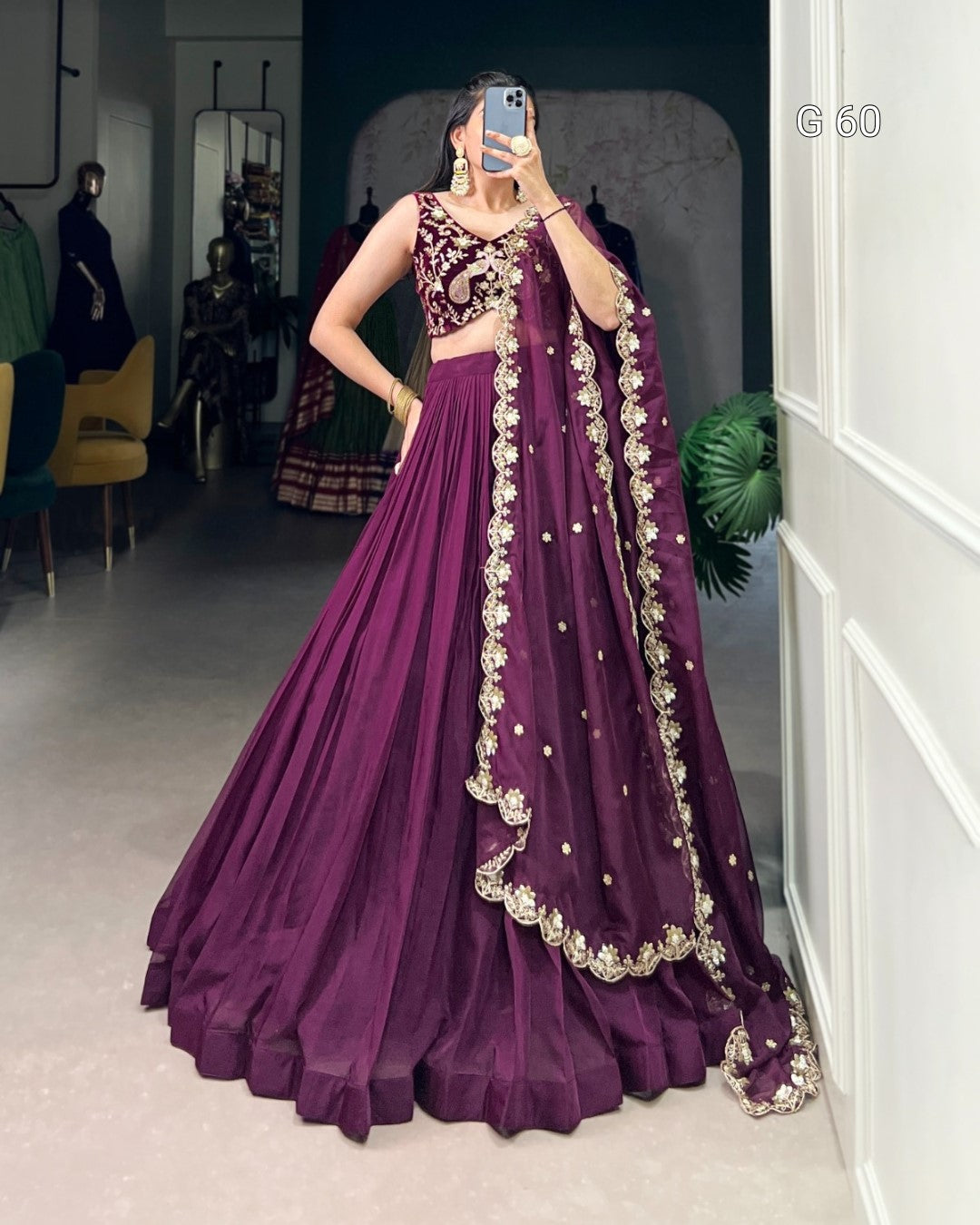 Person wearing a purple embroidered traditional outfit in a room.