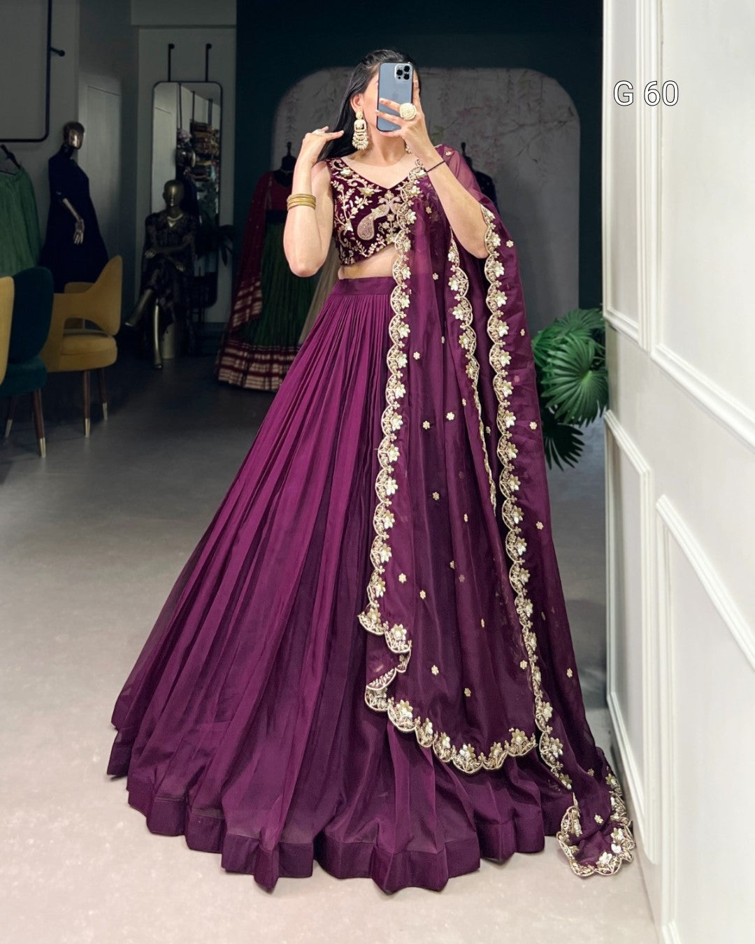 Person wearing a purple embroidered lehenga in a room setting.