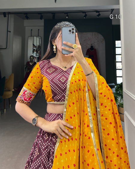 Woman taking a mirror selfie wearing a yellow and purple traditional outfit.