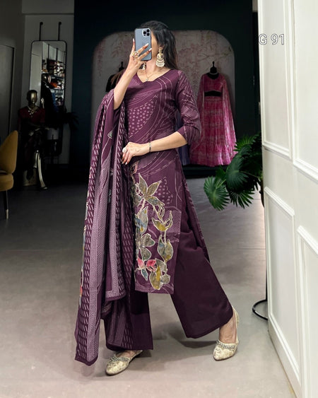 Woman in a purple traditional outfit with floral design standing in front of a mirror.