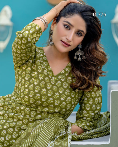 Woman wearing a green patterned outfit against a blue background