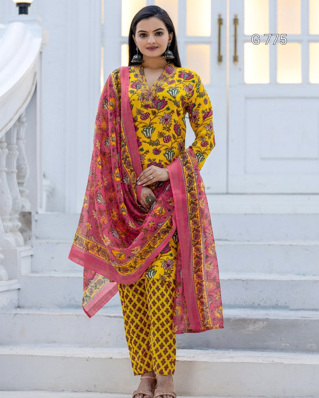 Woman wearing a yellow and pink traditional outfit with a dupatta on a white background