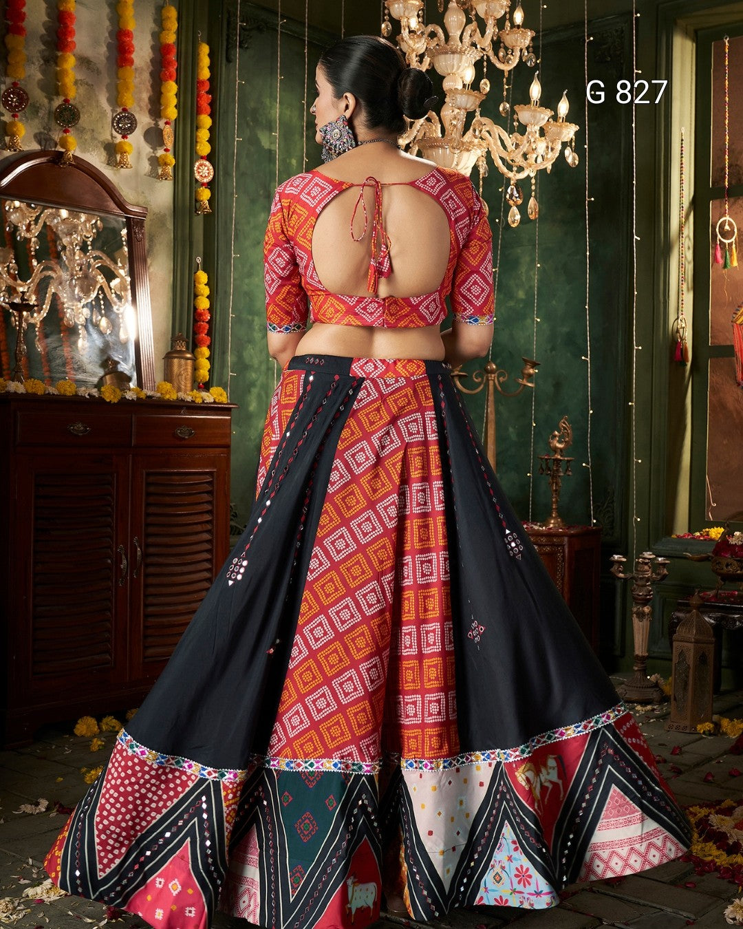 Woman in a colorful traditional outfit with intricate patterns in a decorated room.