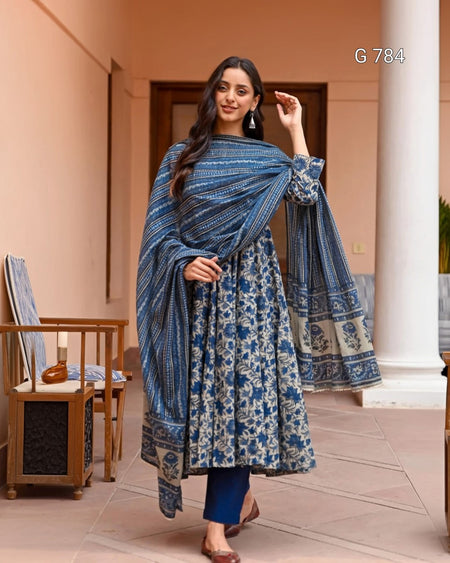 Woman wearing a blue and white patterned traditional outfit in an indoor setting.