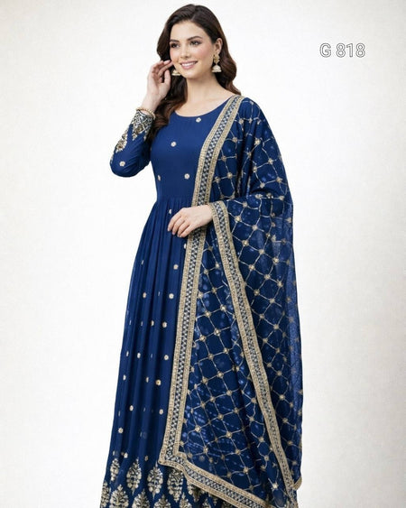 Woman wearing a blue dress with gold embroidery on a white background