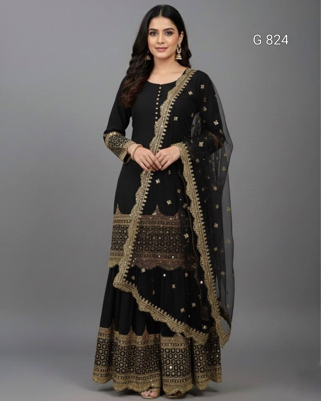Woman wearing a black and gold traditional outfit with a sheer dupatta on a gray background