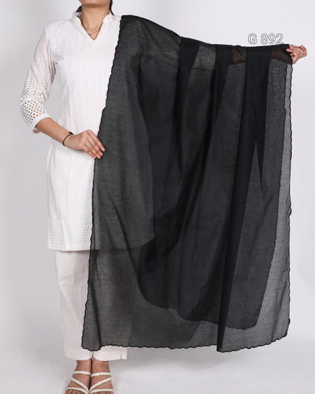 Person holding a black scarf against a white background