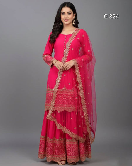 Woman wearing a pink traditional outfit with gold embroidery on a gray background
