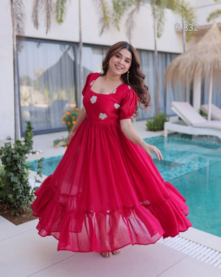 Woman in a red dress standing by a pool with a blurred background