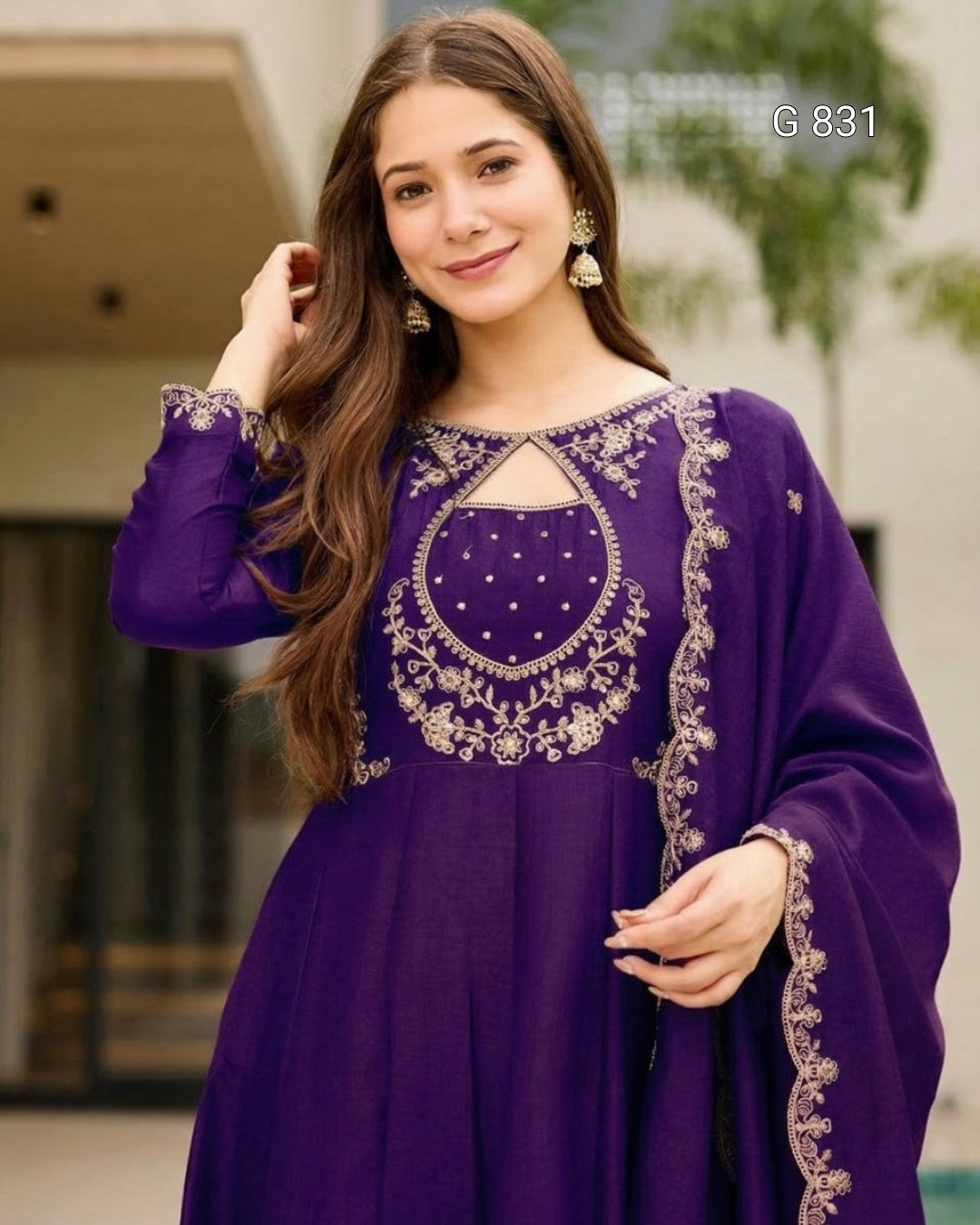 Woman wearing a purple dress with gold embroidery outdoors
