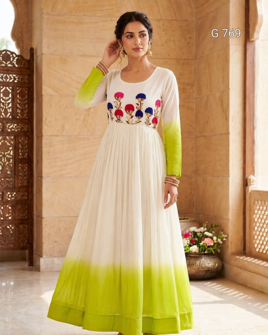 Woman wearing a green and white dress with floral embroidery in a decorative setting.