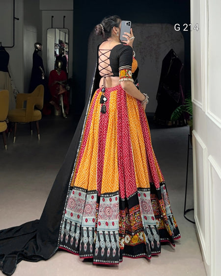 Woman taking a mirror selfie wearing a colorful traditional outfit with intricate patterns.