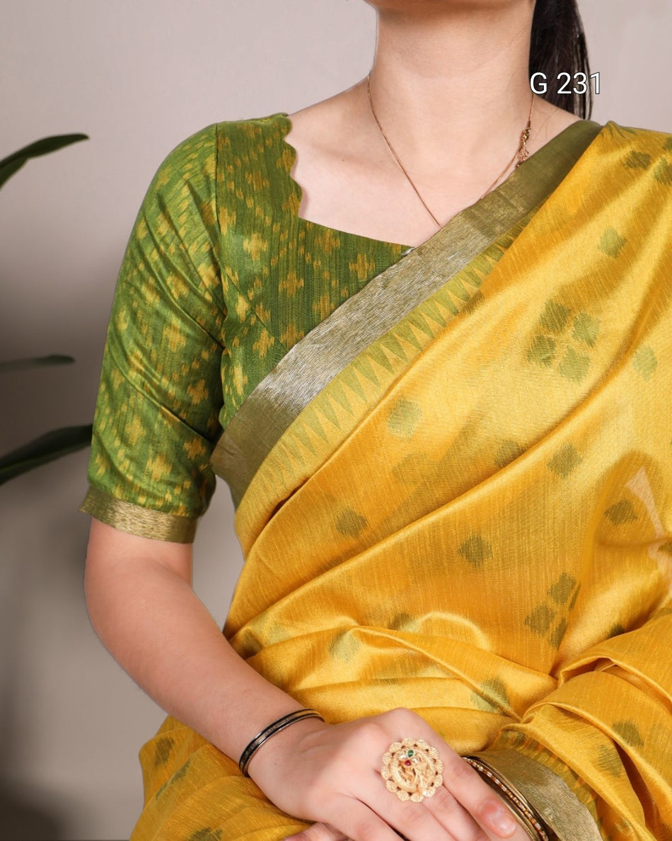 Person wearing a yellow saree with green blouse against a neutral background