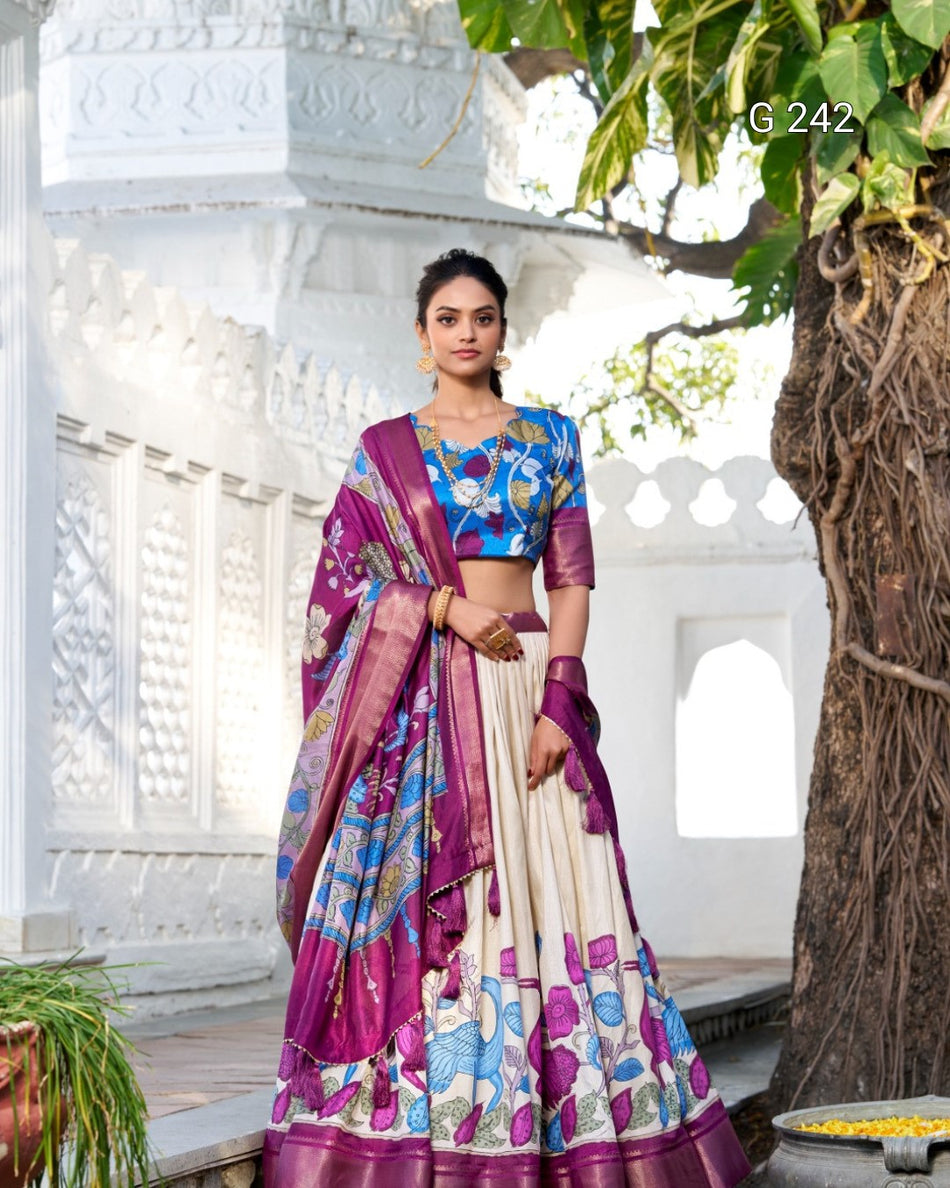 Woman in a traditional outfit with a purple and blue patterned saree in an outdoor setting.