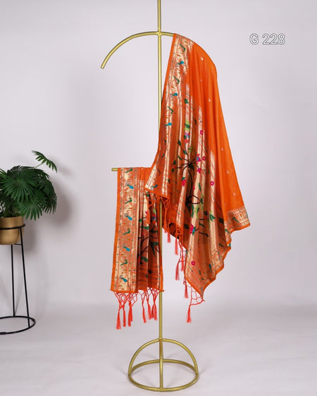Orange scarf with tassels on a gold stand against a white background