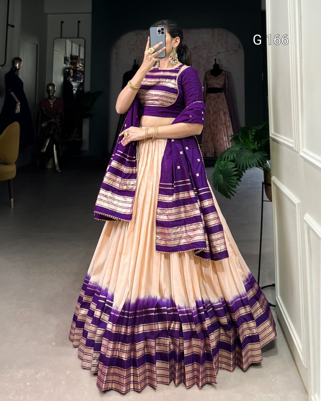Woman wearing a traditional outfit with purple and beige stripes in a room.