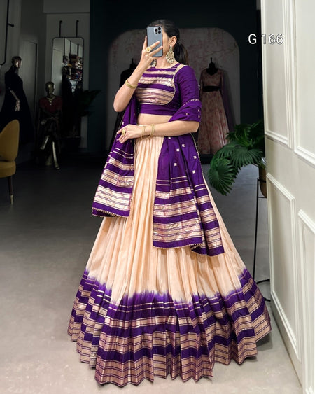 Woman wearing a traditional outfit with purple and beige stripes in a room.