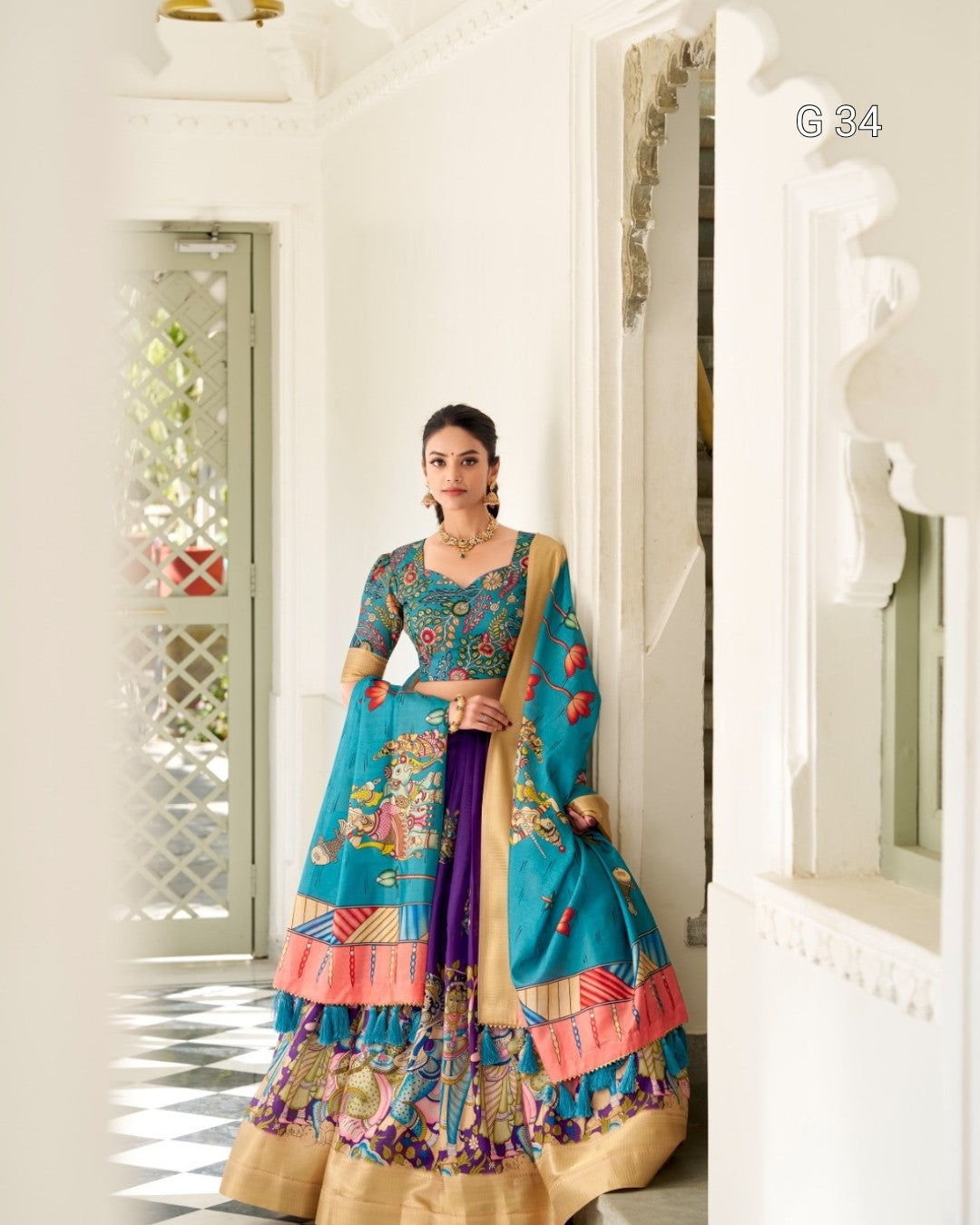 Woman in a colorful traditional outfit standing in a bright room.