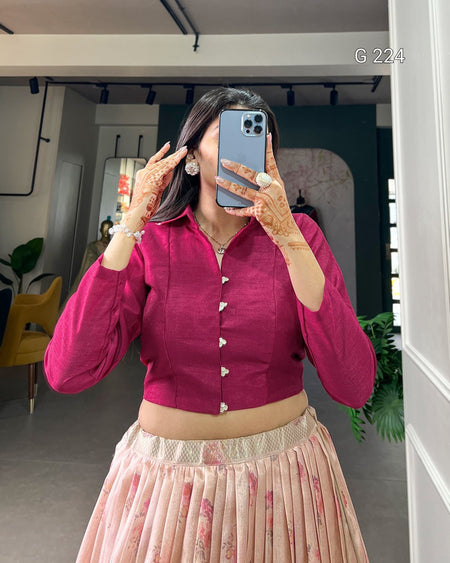 Person wearing a pink top and floral skirt taking a mirror selfie.