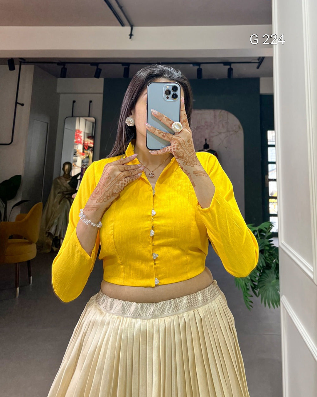 Person wearing a yellow top and beige skirt in an indoor setting.