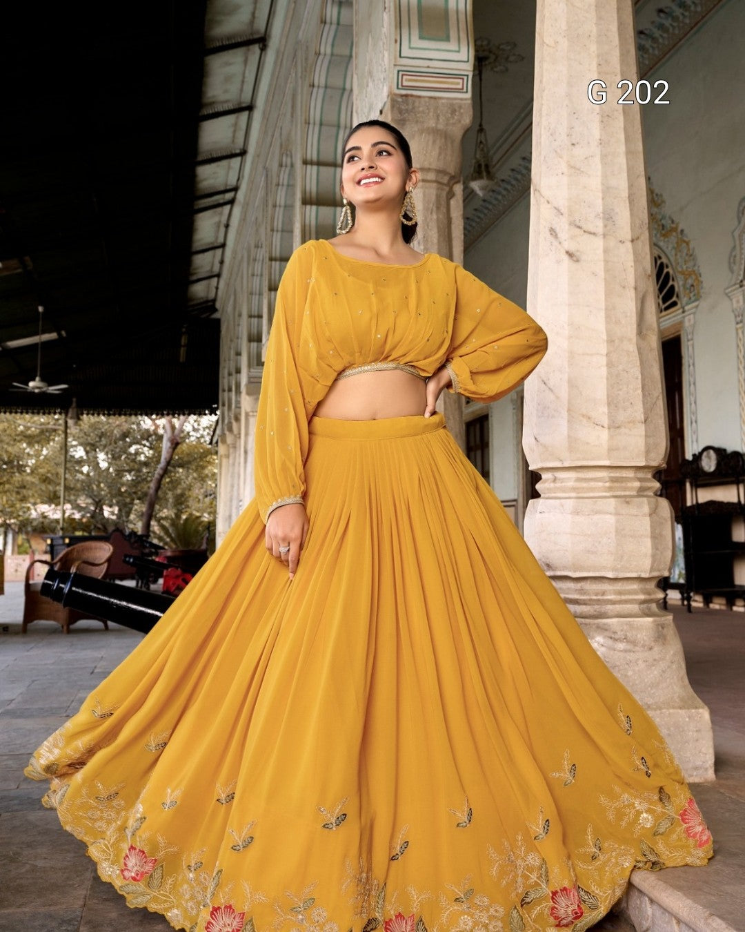Woman in a mustard yellow traditional outfit standing in front of a classical building.