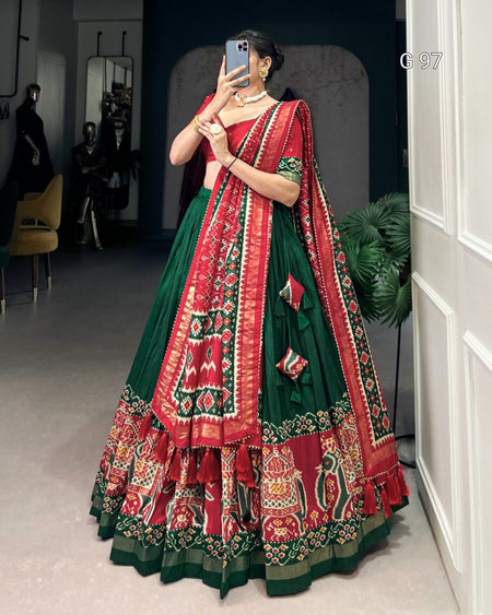 Woman in a red and green traditional outfit taking a mirror selfie.
