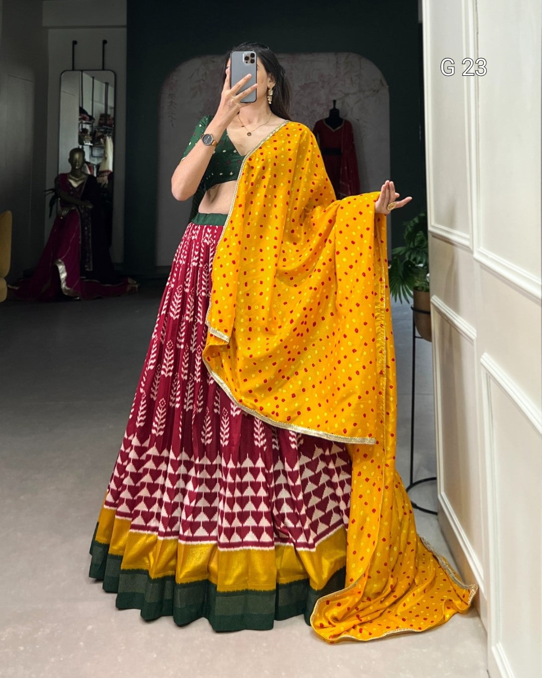 Person wearing a traditional outfit with a yellow dupatta in a room.